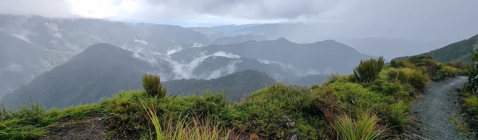 Bush, shear rock faces, ghostly cloud lingering over bush clad mountains